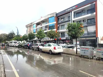 KUŞADASI DAVUTLAR MENDERES CADDESI ÜZERINDE  ÇIFT CEPHE SIFIR BINADA ZEMINDE GENIŞ SATILIK MAĞAZA